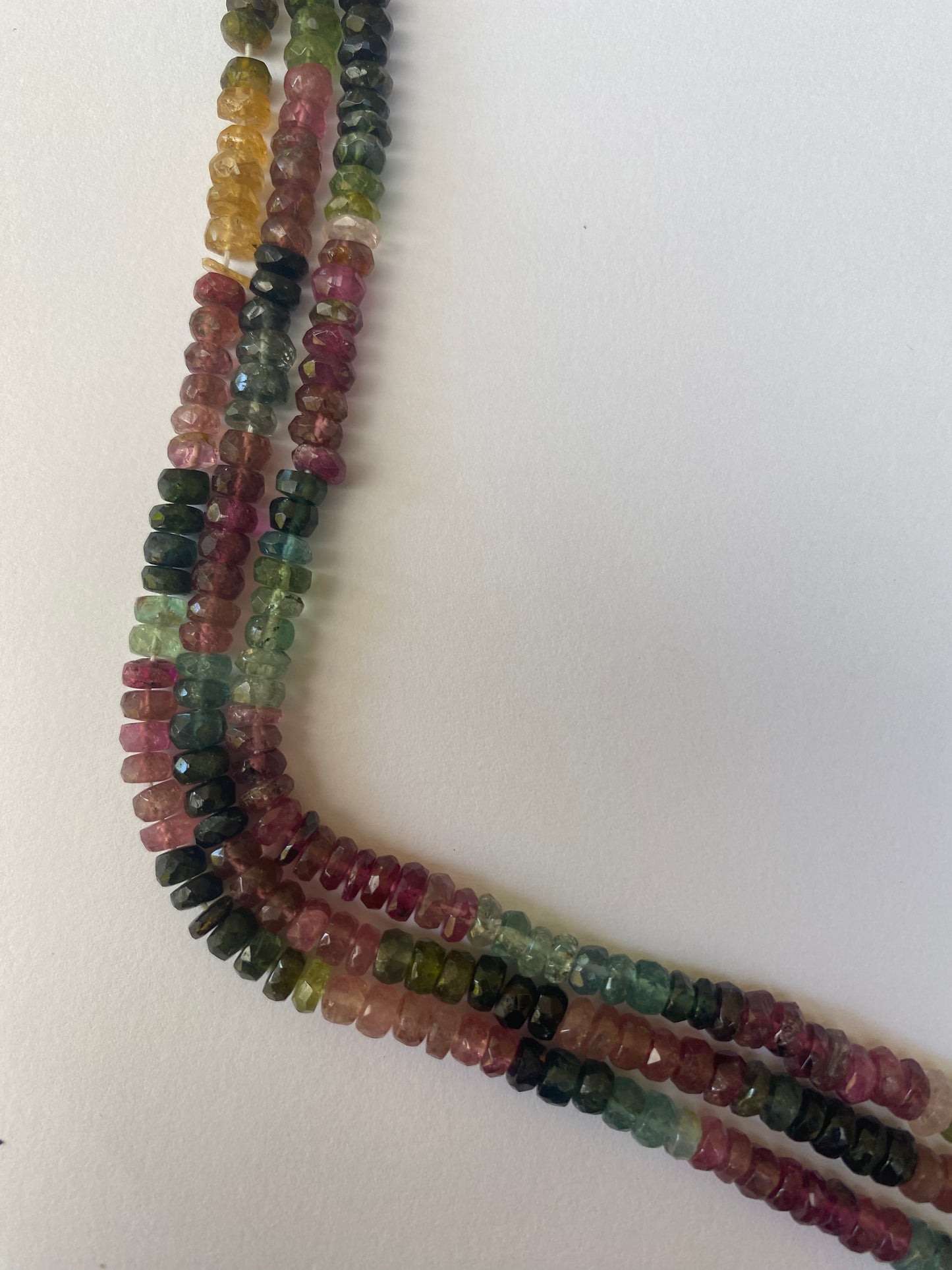 Colourful strands of 4.4-4.8mm faceted rondelle tourmaline beads, displaying a beautiful array of hues.