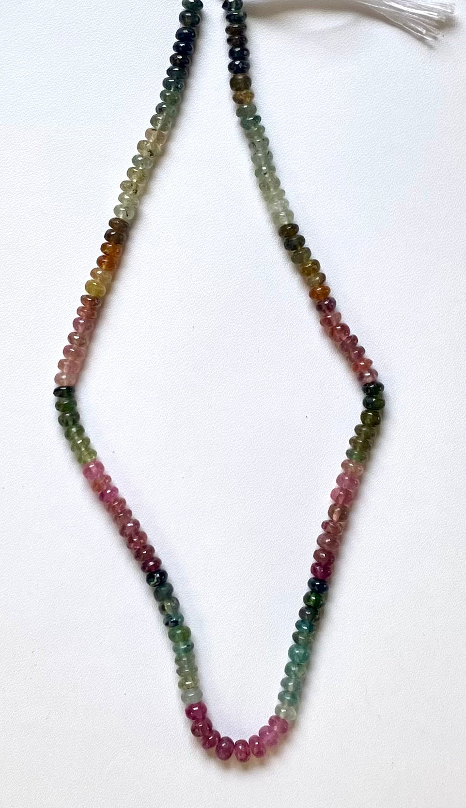 Strand of 5mm multicoloured tourmaline beads, showcasing vibrant hues and intricate design.