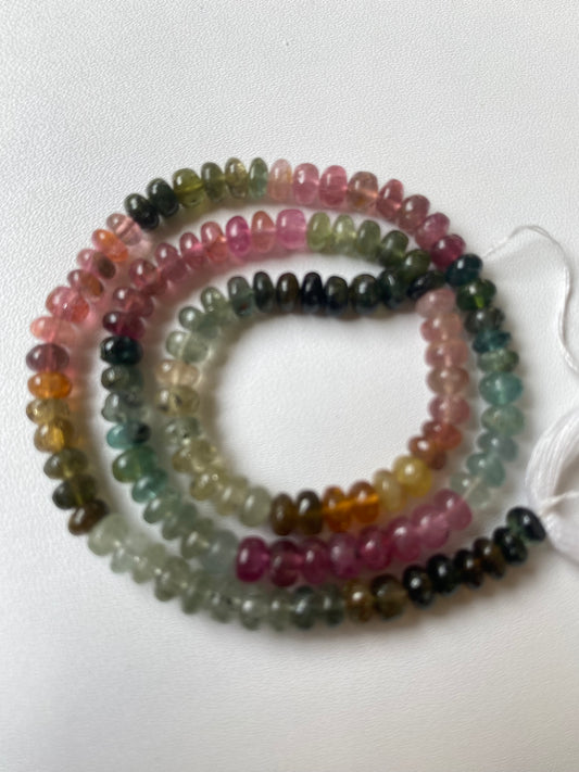 Multi-coloured strand made of 5mm smooth rondelle tourmaline beads, displaying a stunning array of colours and textures.