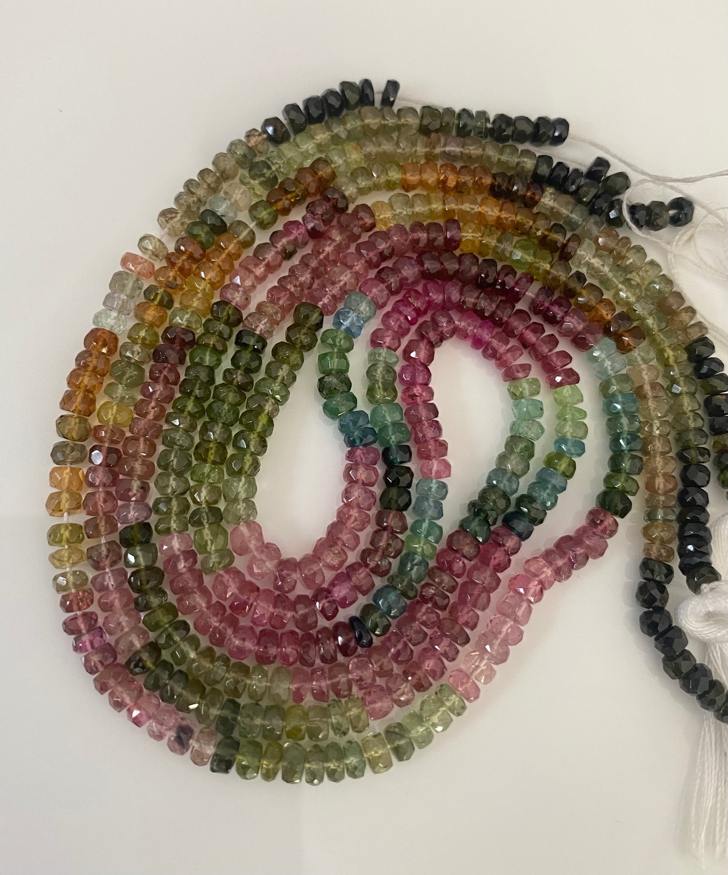 A vibrant rows of micro-cut watermelon tourmaline beads, showcasing a spectrum of colours in 3.4-3.8mm sizes.