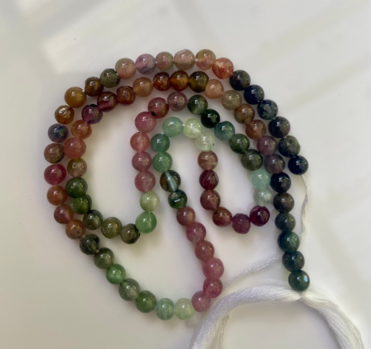A colourful strand adorned with 4.5mm smooth spherical beads of watermelon tourmaline, showcasing a beautiful design.