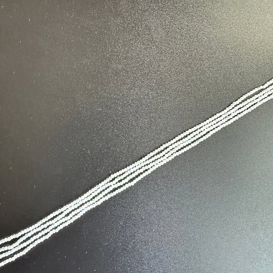 Close-up of White Rainbow Moonstone beads reveals their subtle iridescence and fine faceting.