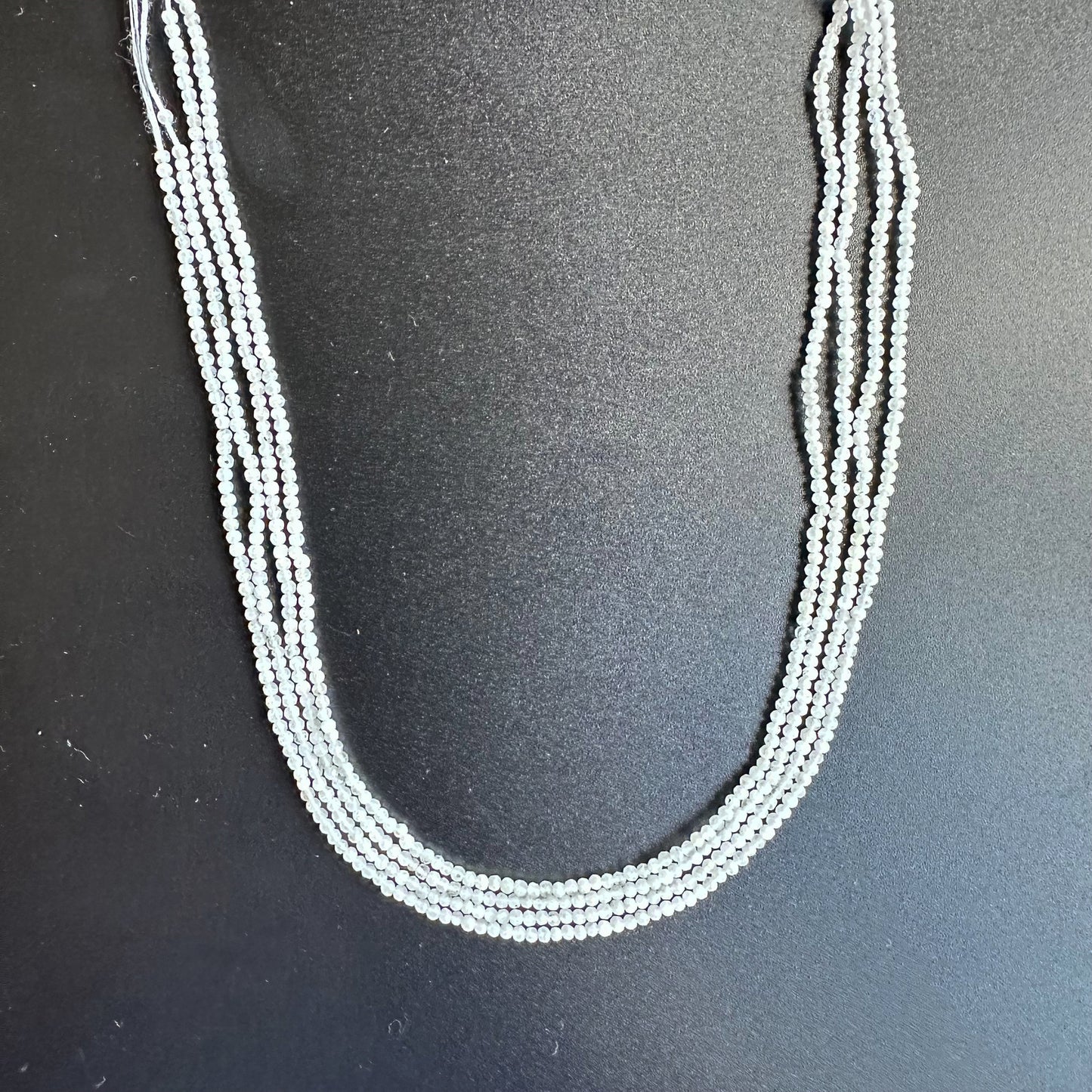 White Rainbow Moonstone rondelle beads sparkle under gentle lighting, enhancing their opalescent glow.