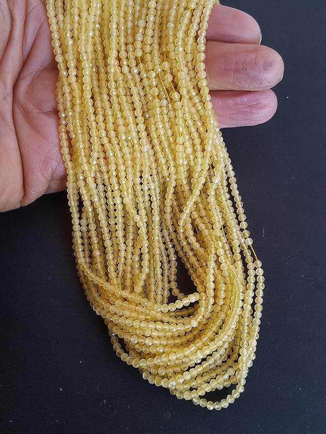 A hand displays a beautiful yellow faceted Chalcedony gemstone beads, emphasising its faceted design and vibrant colour.