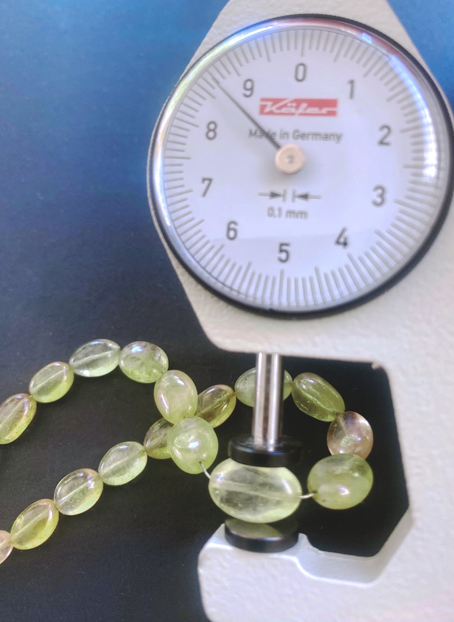 A dial gauge measures the Yellow Sapphire smooth oval gemstone.