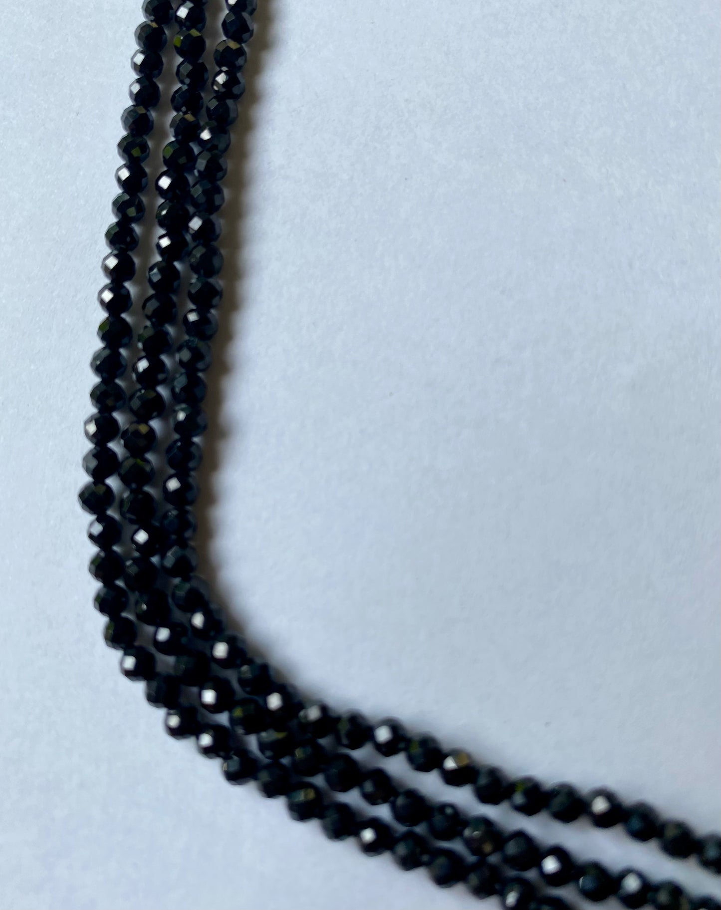 Elegant strands adorned with 3.0mm black spinel micro-faceted rondelle beads, showcasing a sleek design.