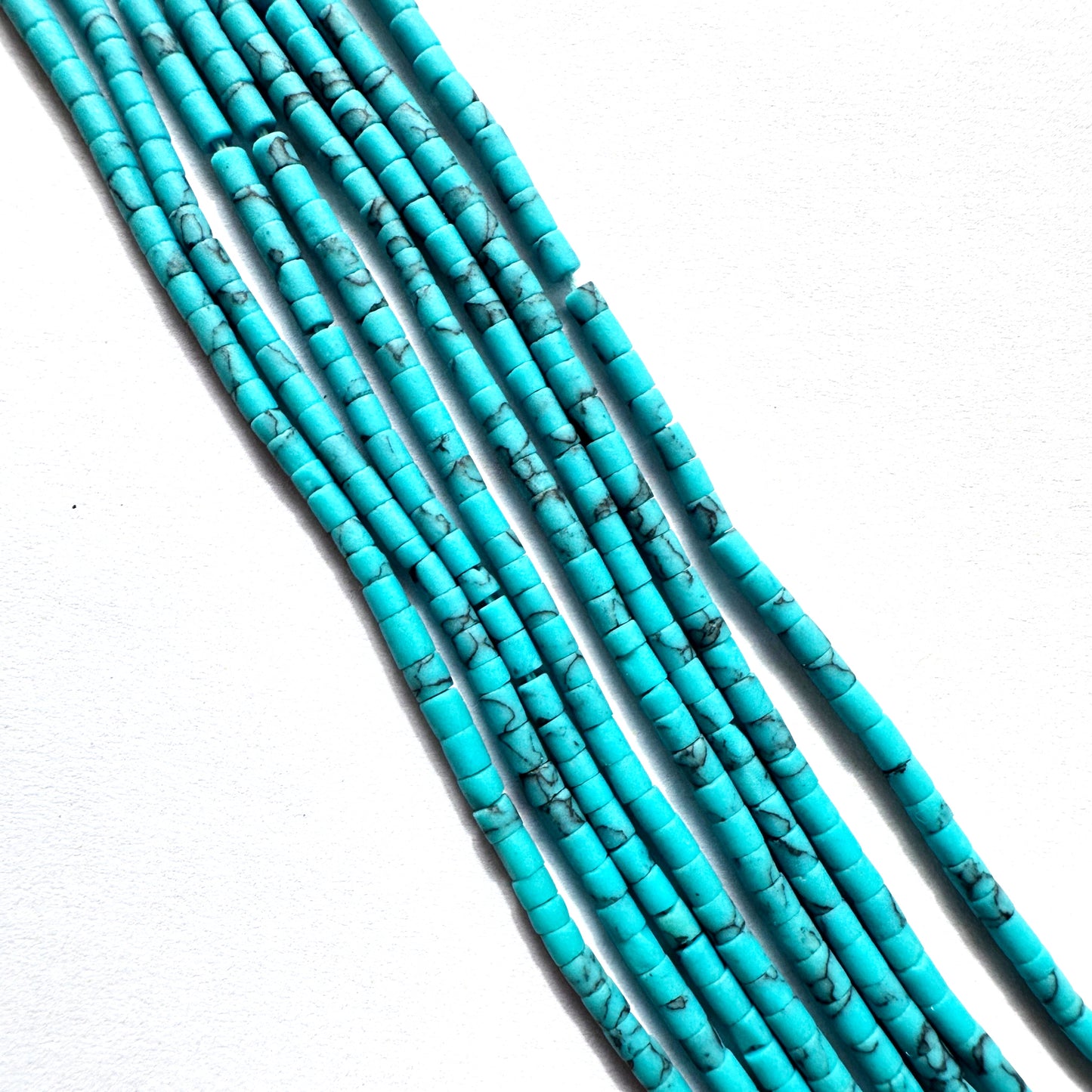 Close-up of Afghan tube-shaped beads showing polished finish and consistent sizing.