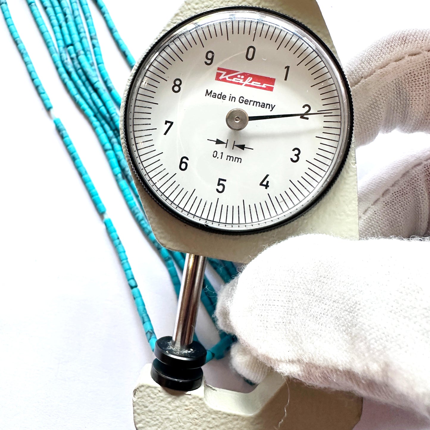 A dial gauge measures the Afghan tube-shaped Heishi 2.0mm gemstone.
