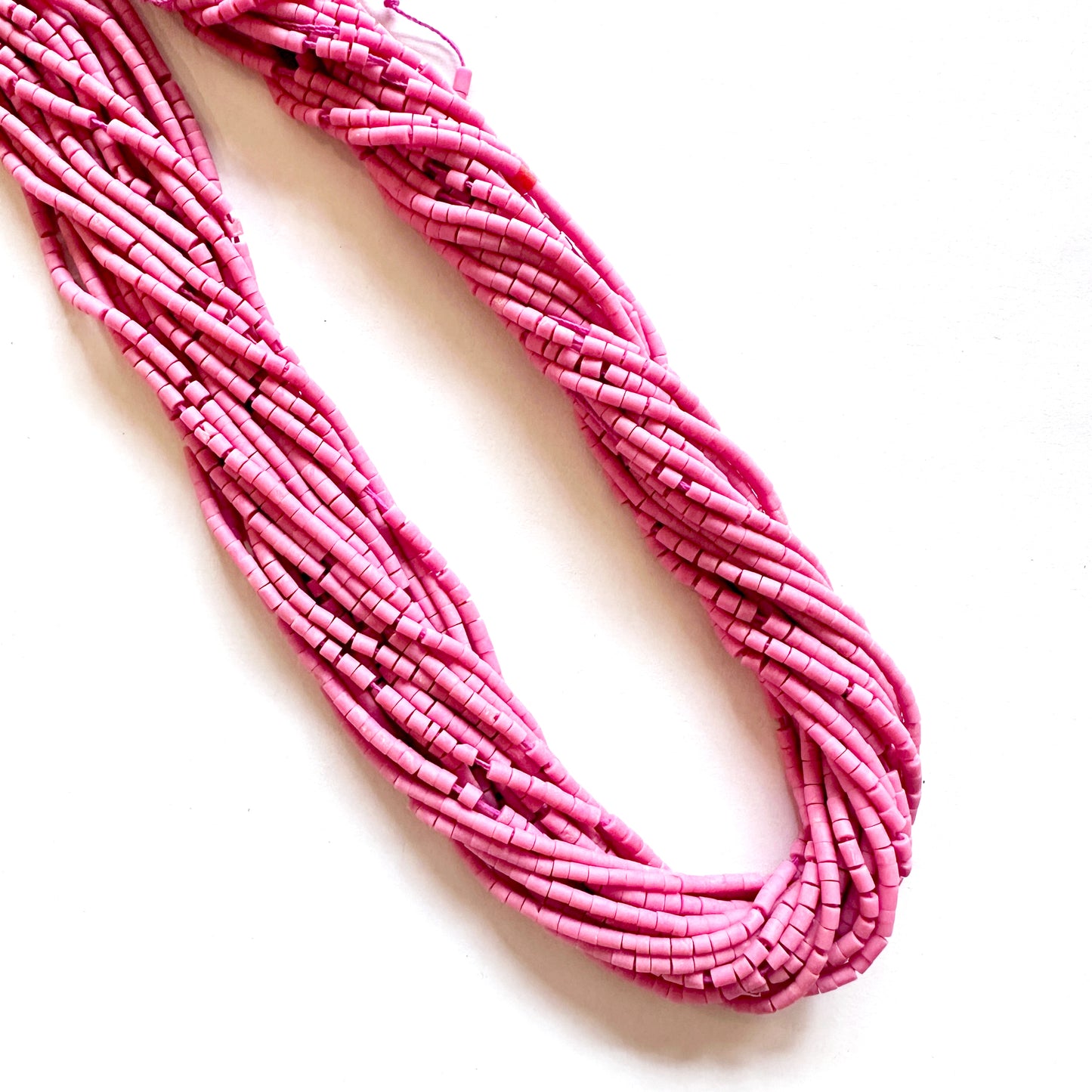Close-up of pink Afghan Tube Heishi beads highlighting even cuts and gentle matte finish.
