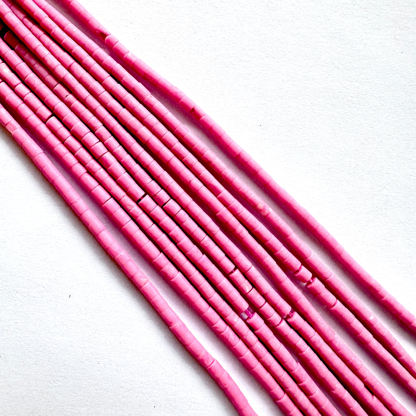 Close up of Pink afghan beads on a white background