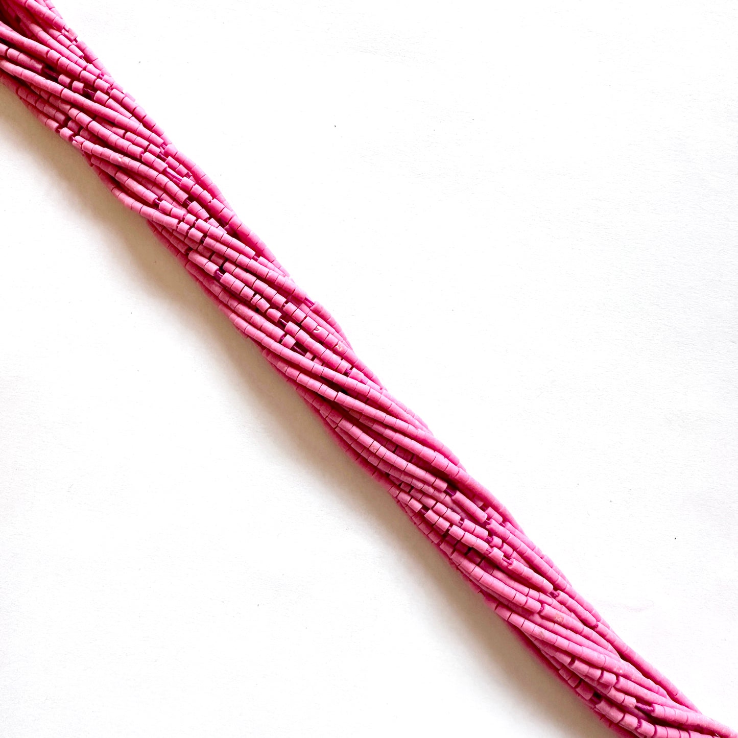 Afghan Pink Heishi beads in tube shape shown in soft blush colour across a 31cm strand.