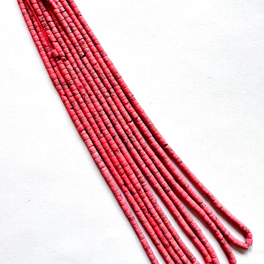 Cylindrical Afghan Heishi gemstone beads arranged in smooth alignment with natural matte texture.