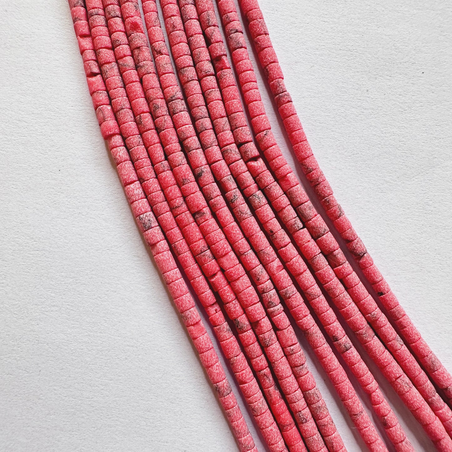 Close-up view of finely cut Afghan Heishi beads showing quality craftsmanship and even bead holes.