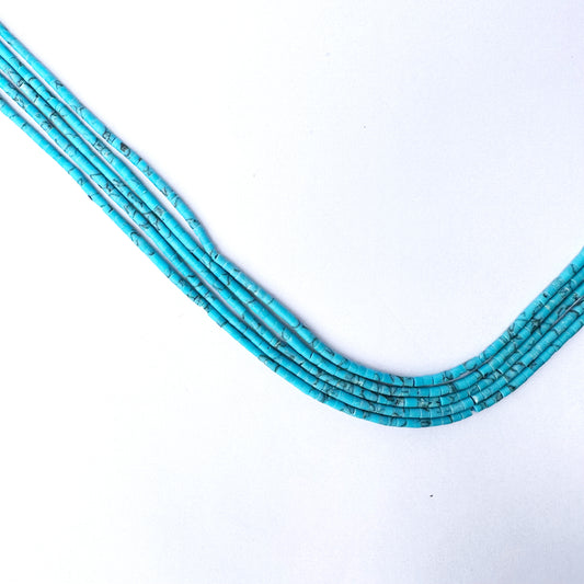 Slim Afghan Heishi beads arranged in tube-shaped formation with glossy finish.