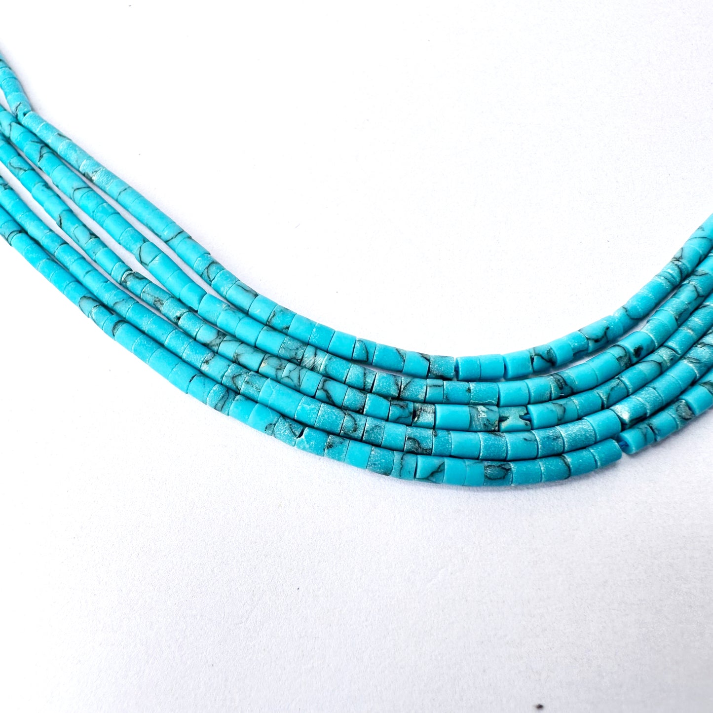Detailed close-up of Afghan beads showing cylindrical shape and refined polish.