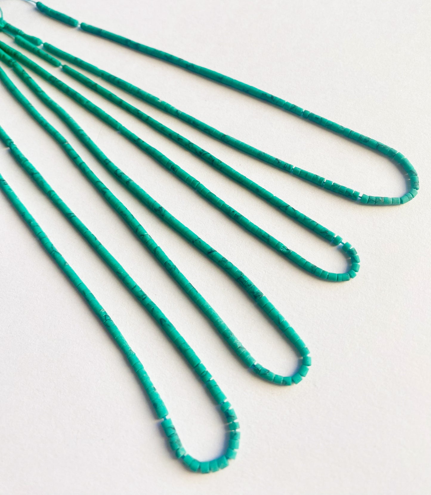 Tube-shaped Afghan Heishi beads in 2mm size arranged neatly on a 32cm strand with natural matte finish.