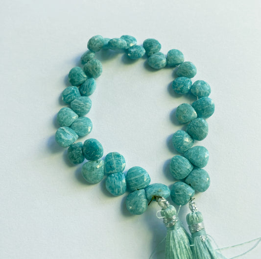 Turquoise beaded necklace with tassel on a light gray background