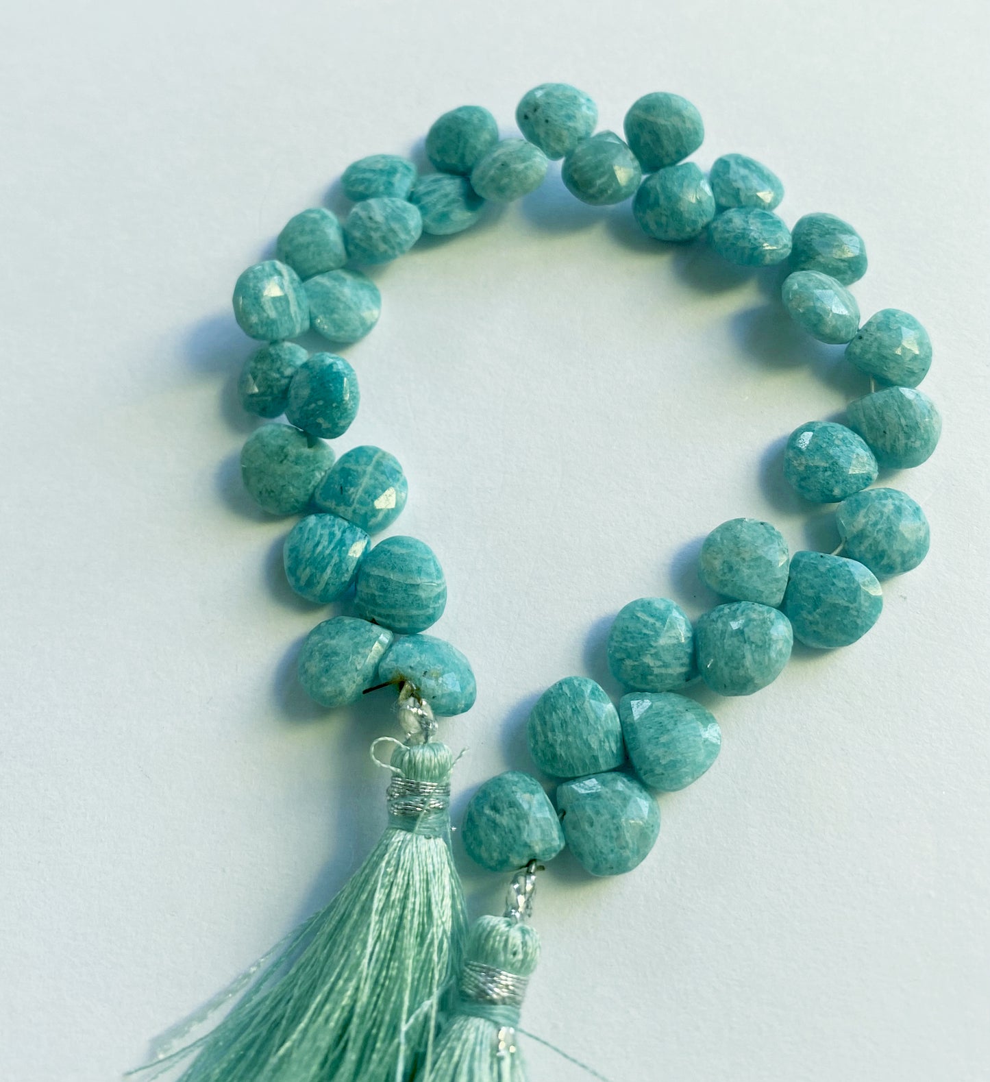 Amazonite gemstone hearts arranged in a curved 21cm strand with consistent colour and detail.