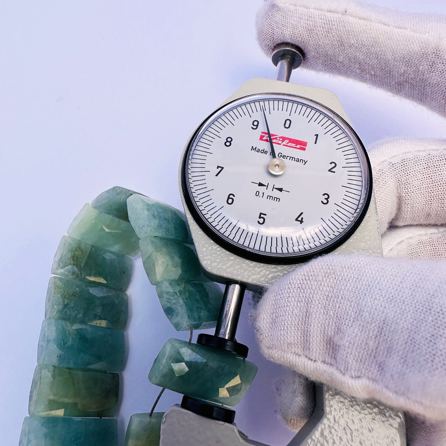 A dial gauge measures the Amazonite faceted rectangle 21×9.3–9.5mm gemstone.