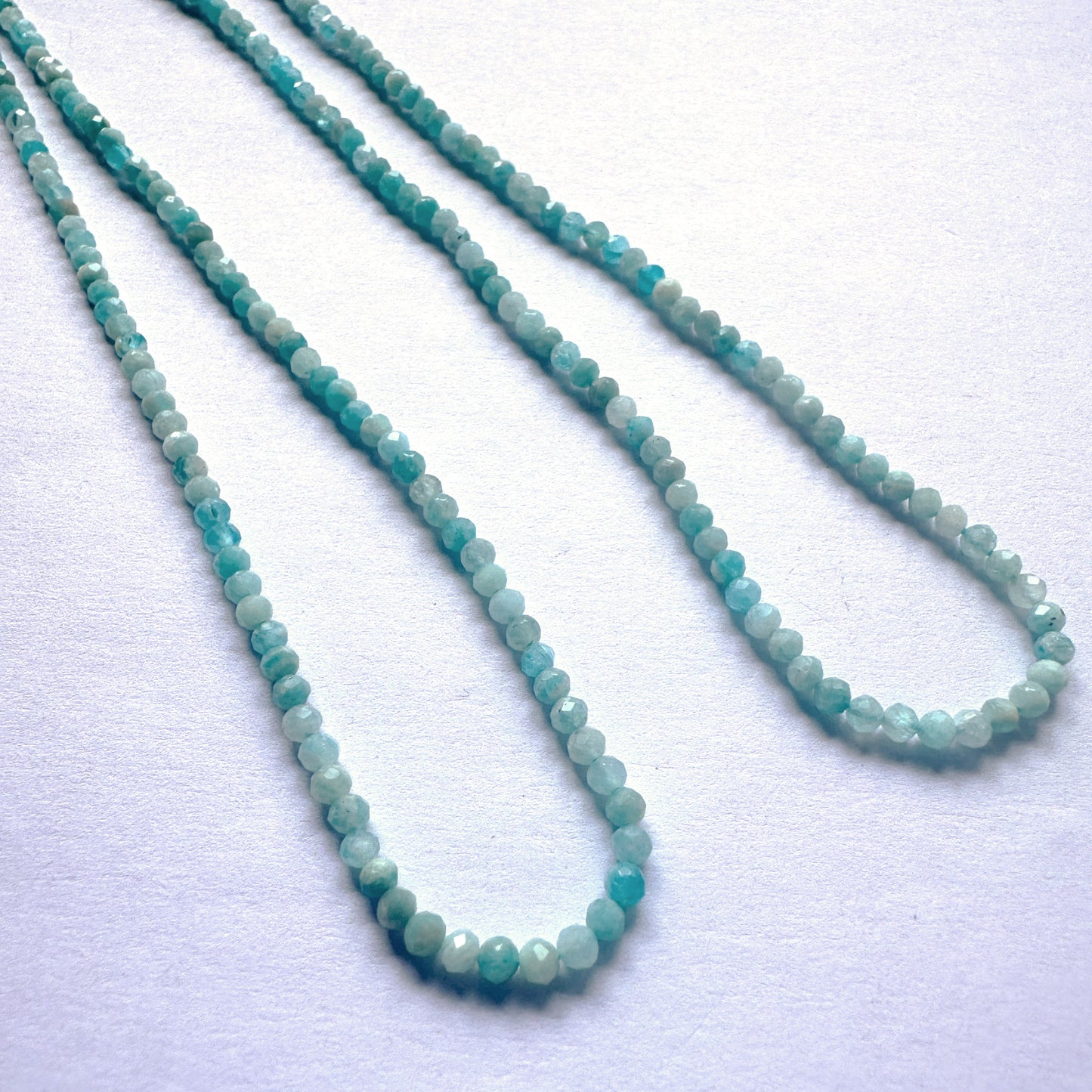 Sparkling Amazonite beads in rondelle cut, reflecting light with subtle brilliance and smooth polish.