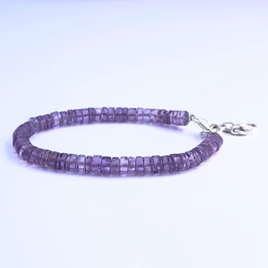 Close-up of polished amethyst stone beads arranged in a stylish bracelet.