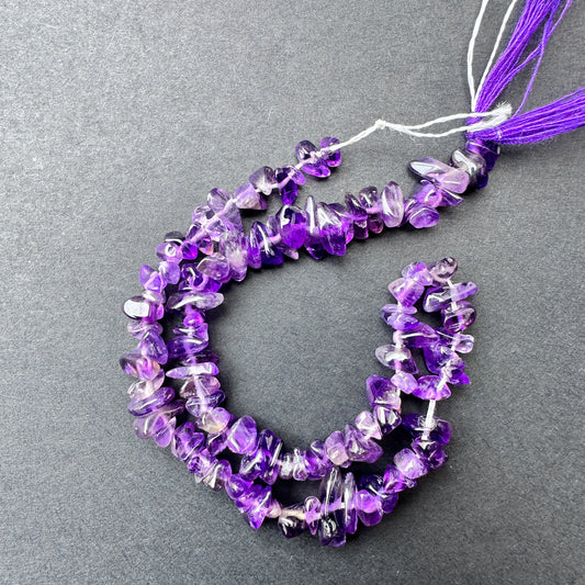 Close-up of Amethyst stone beads showing smooth chip cut and natural gemstone texture.