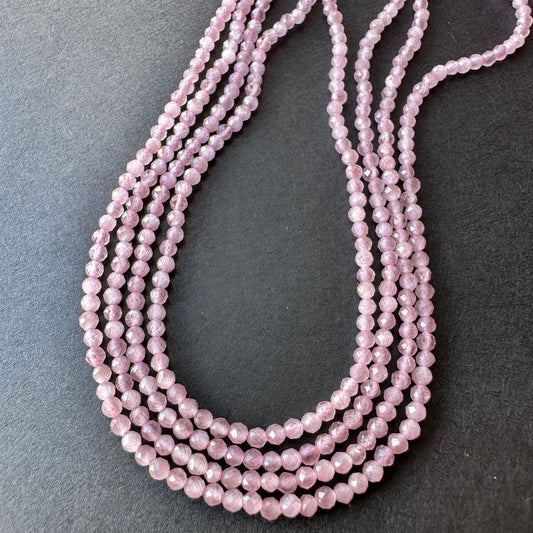 Close-up of natural gemstone beads in petite 2mm size with sparkling facets and polished finish