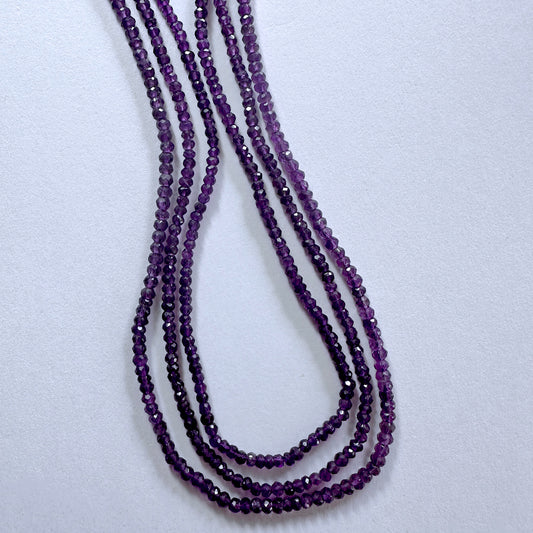 Close-up of amethyst rondelle beads showing vibrant colour and precision faceting.