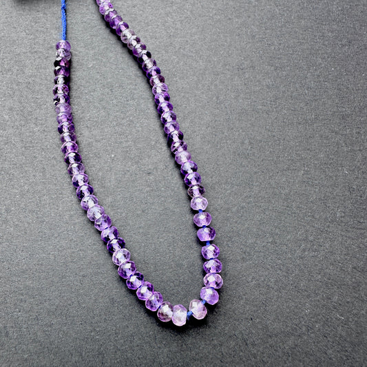 Close-up of Amethyst stone beads showing faceted cut and natural gemstone sparkle.