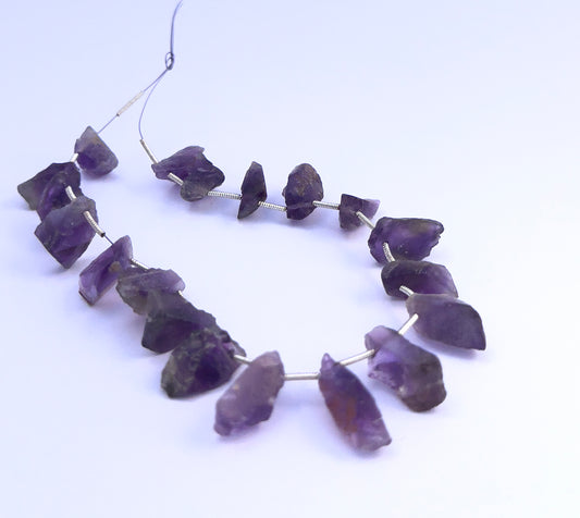 Close-up of Amethyst gemstone beads showing raw texture and unpolished finish.
