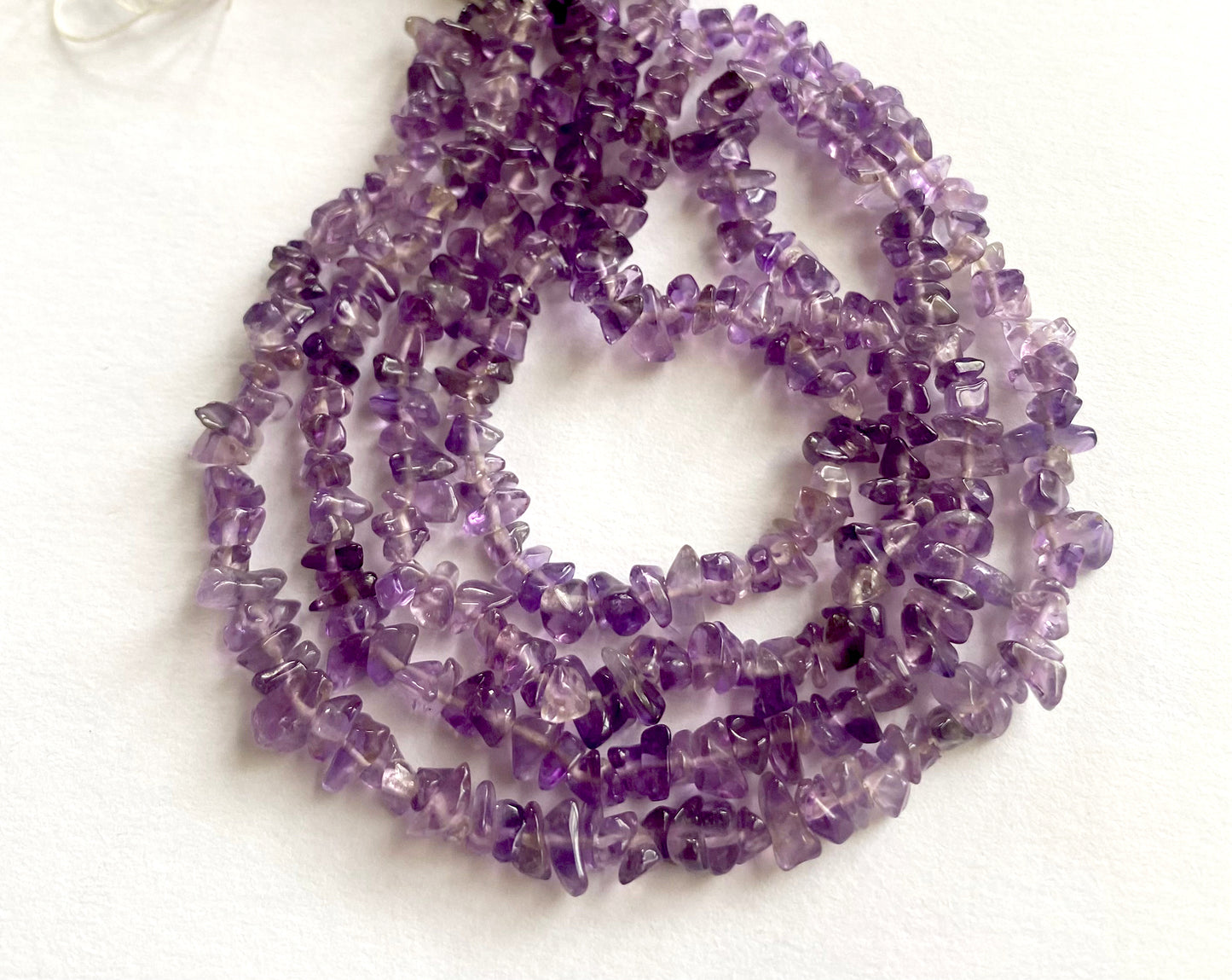 Varied purple tones reflected in polished Amethyst chips arranged in a spiral.