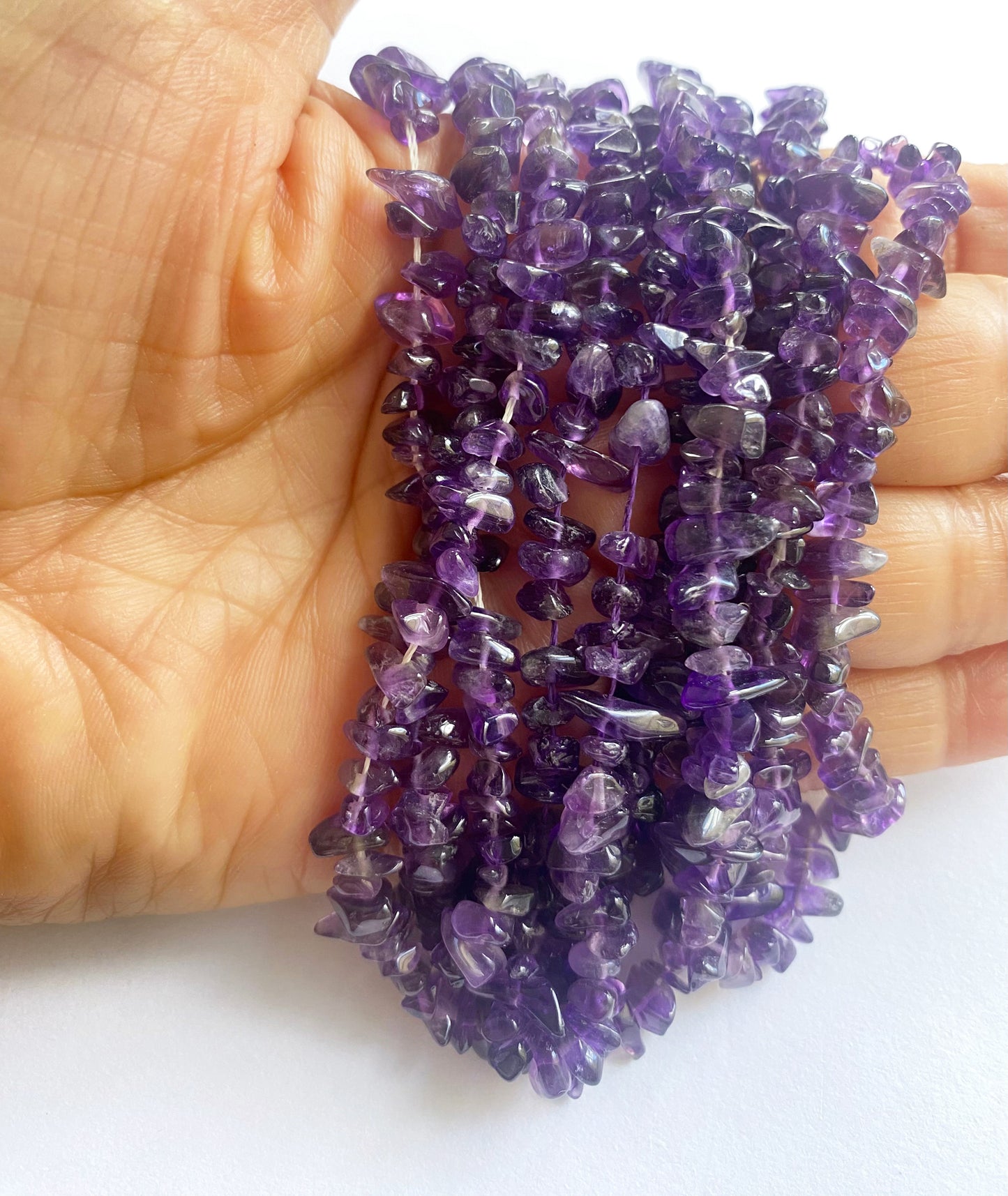 A dial gauge measures the Amethyst smooth chip 5–8.5mm gemstone for detailed sizing accuracy.