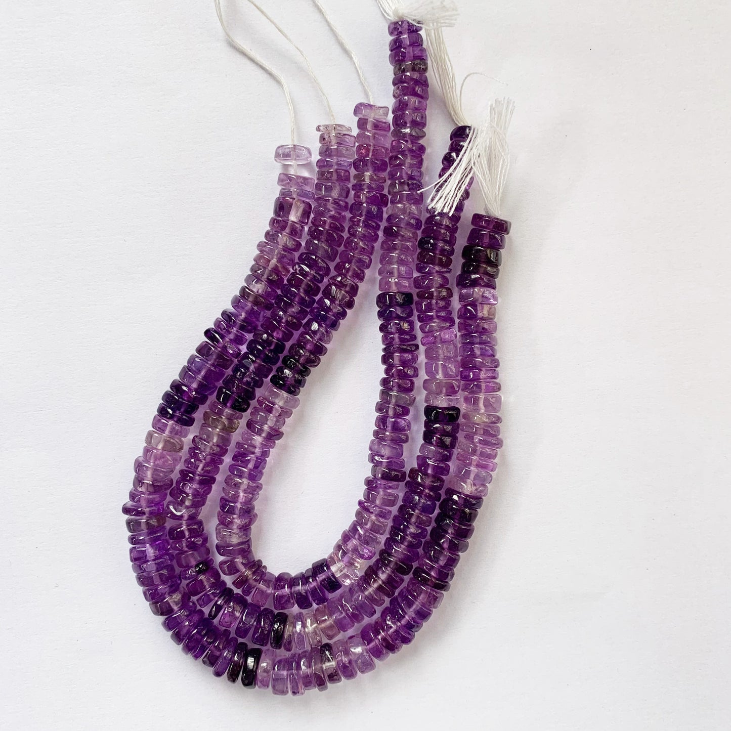 Detailed view of translucent purple Amethyst beads revealing consistent shape and top-grade clarity.