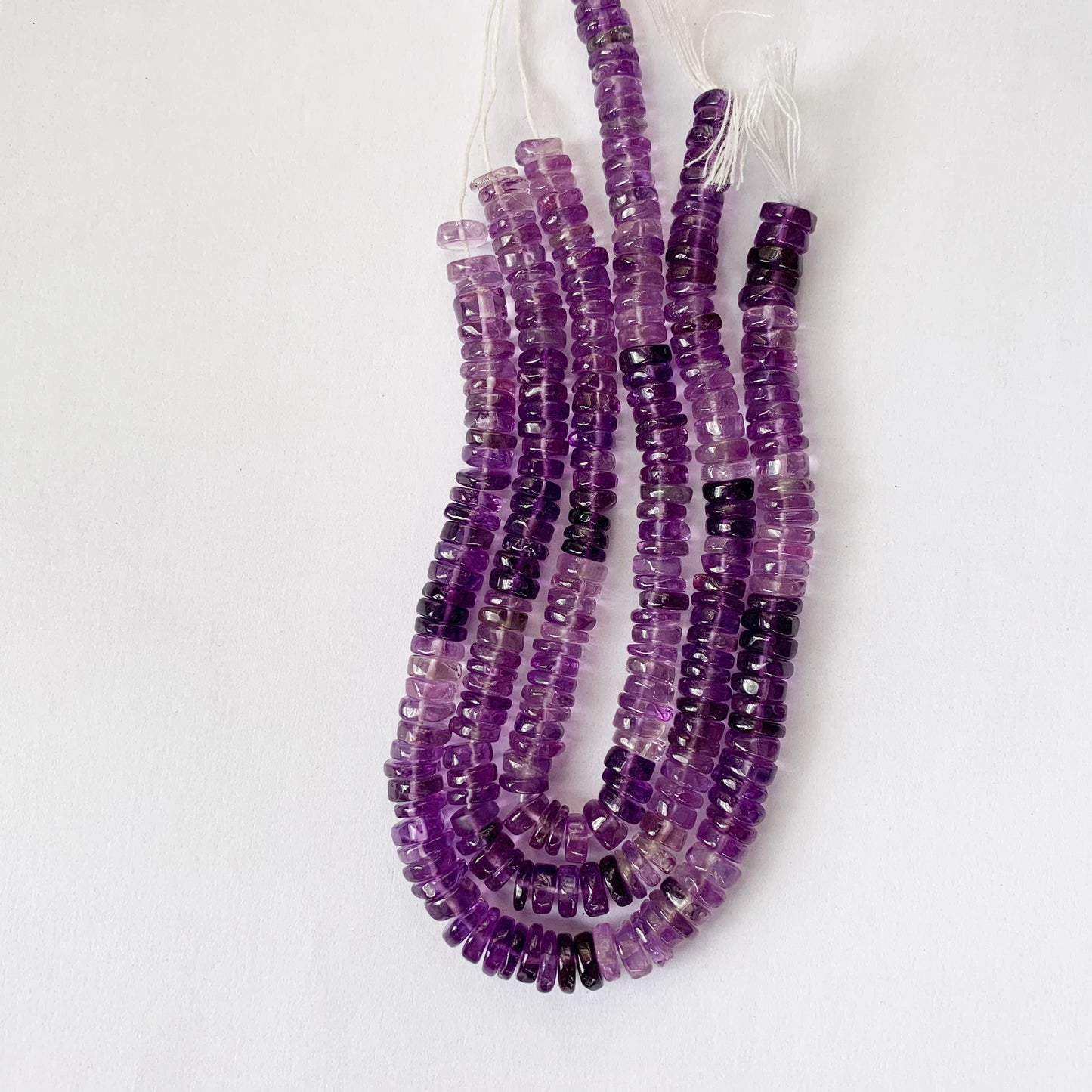 Natural daylight highlights the shine and lustrous texture of Amethyst Heishi cut gemstones.