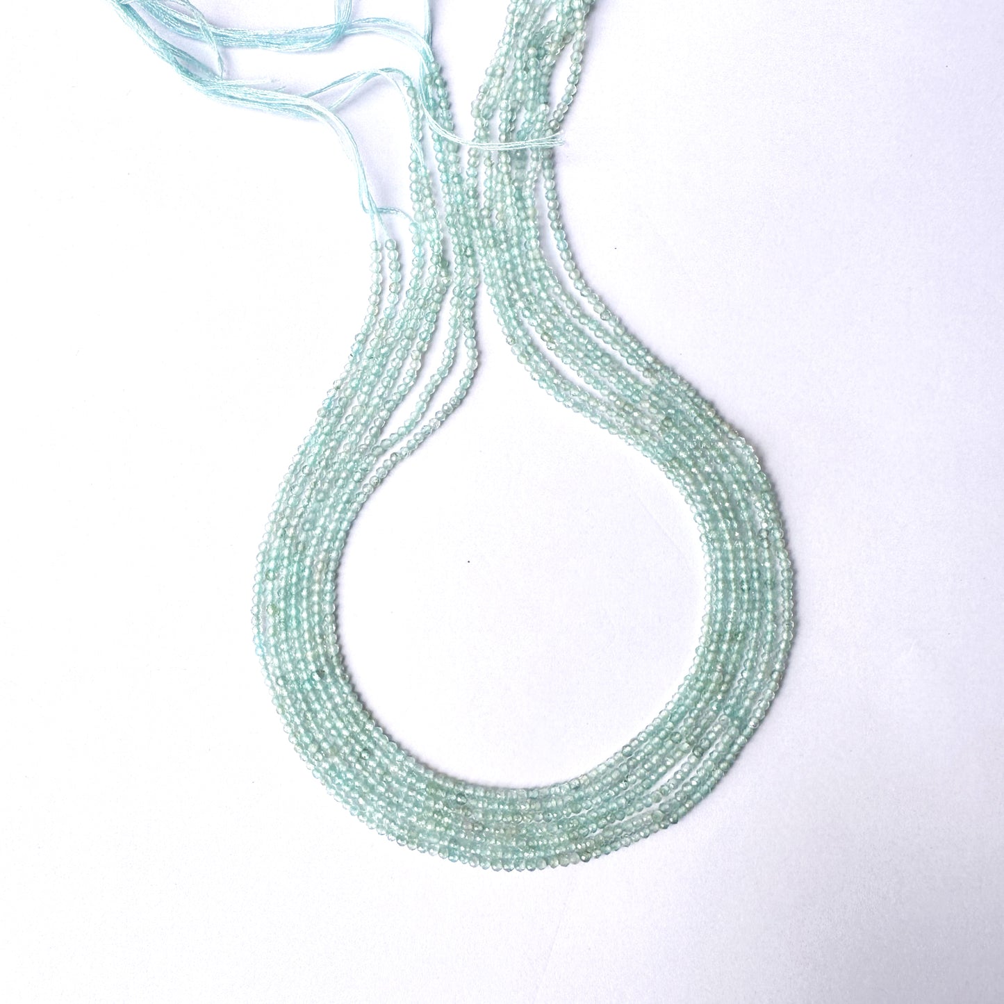 Close-up of Aquamarine gemstone beads showing delicate cuts and polished texture.