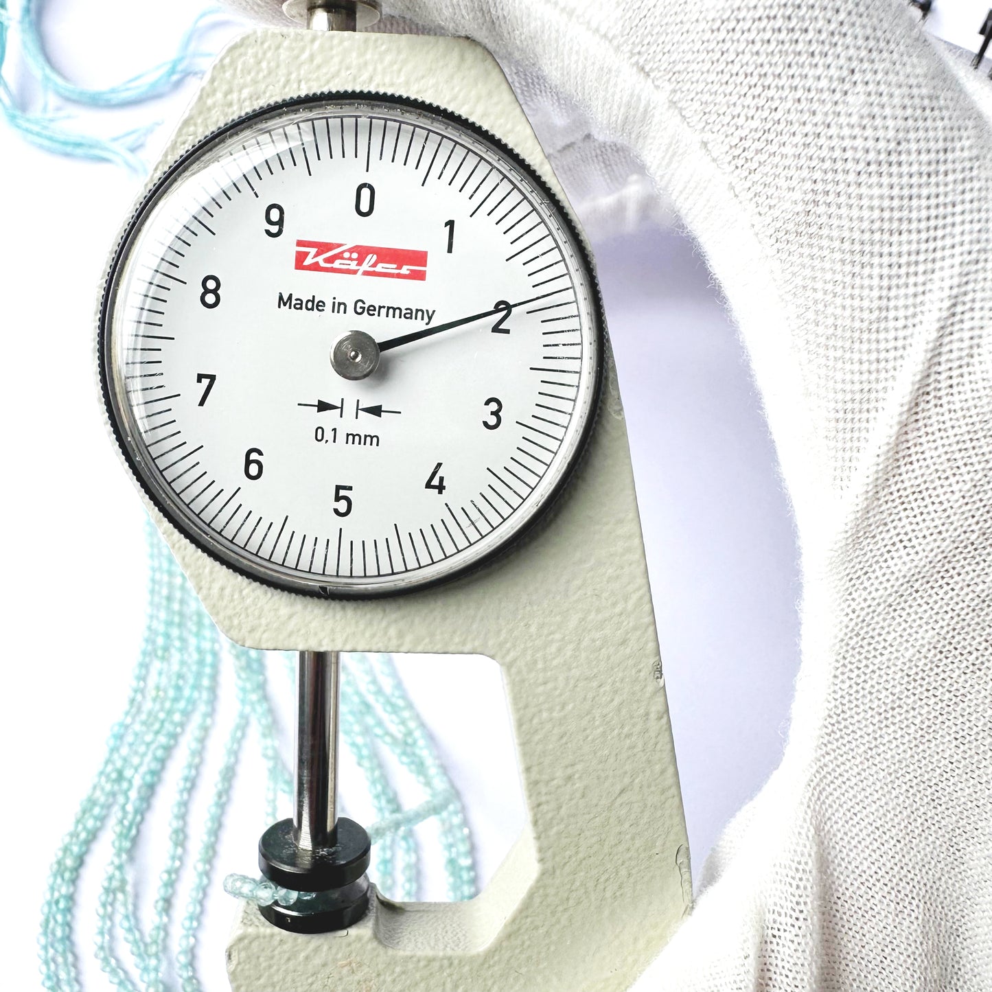 A dial gauge measures the Aquamarine faceted rondelle 2.0mm gemstone.