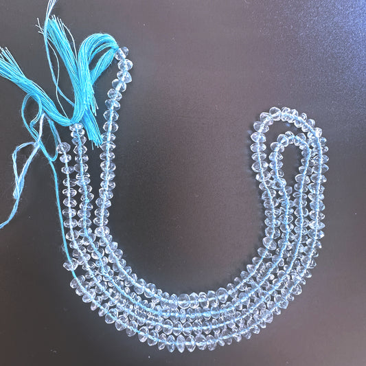 Close-up of aquamarine rondelle beads showing faceted surfaces and consistent sizing across the strand.
