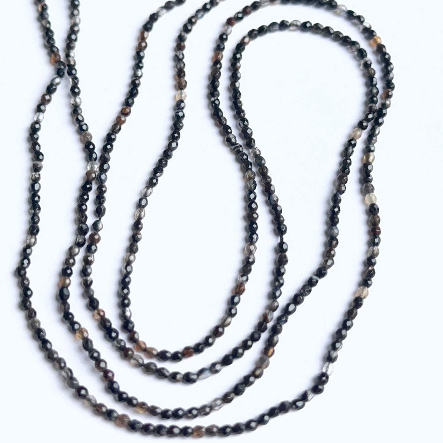 Black fluorite rondelle beads photographed to show their polished finish and suitability for handmade jewellery components.