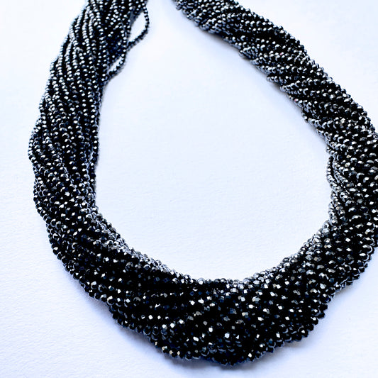 Close-up of Black Spinel stone beads showing precision faceted cut and natural gemstone shine.