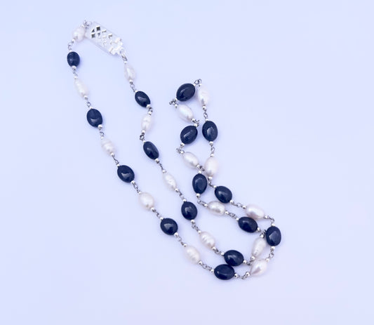 Close-up of polished Sapphire and Pearl gemstone beads showing glossy finish and elegant arrangement.