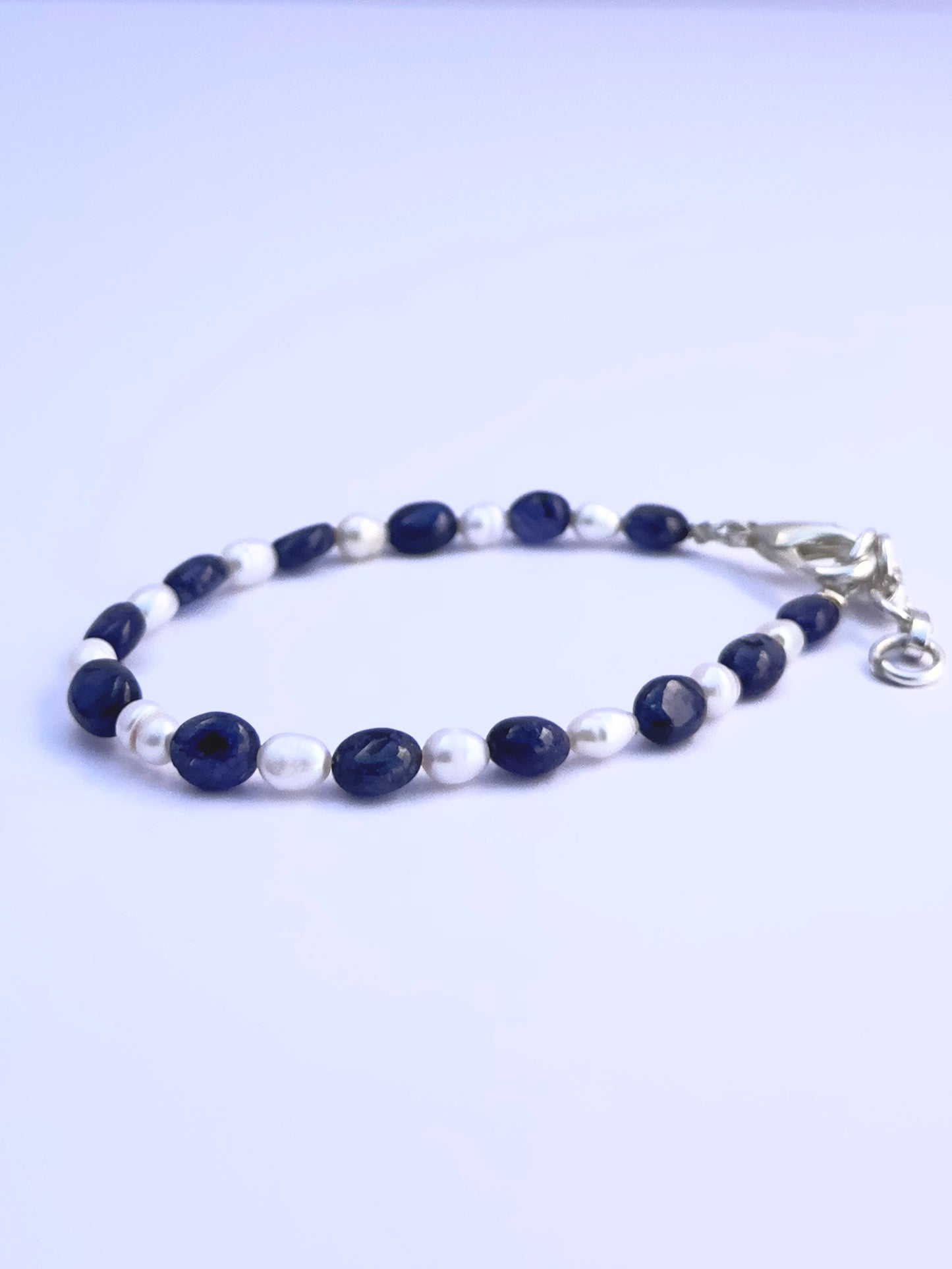 Natural gemstone beads in rich blue and soft white, styled into a sleek adjustable bracelet.