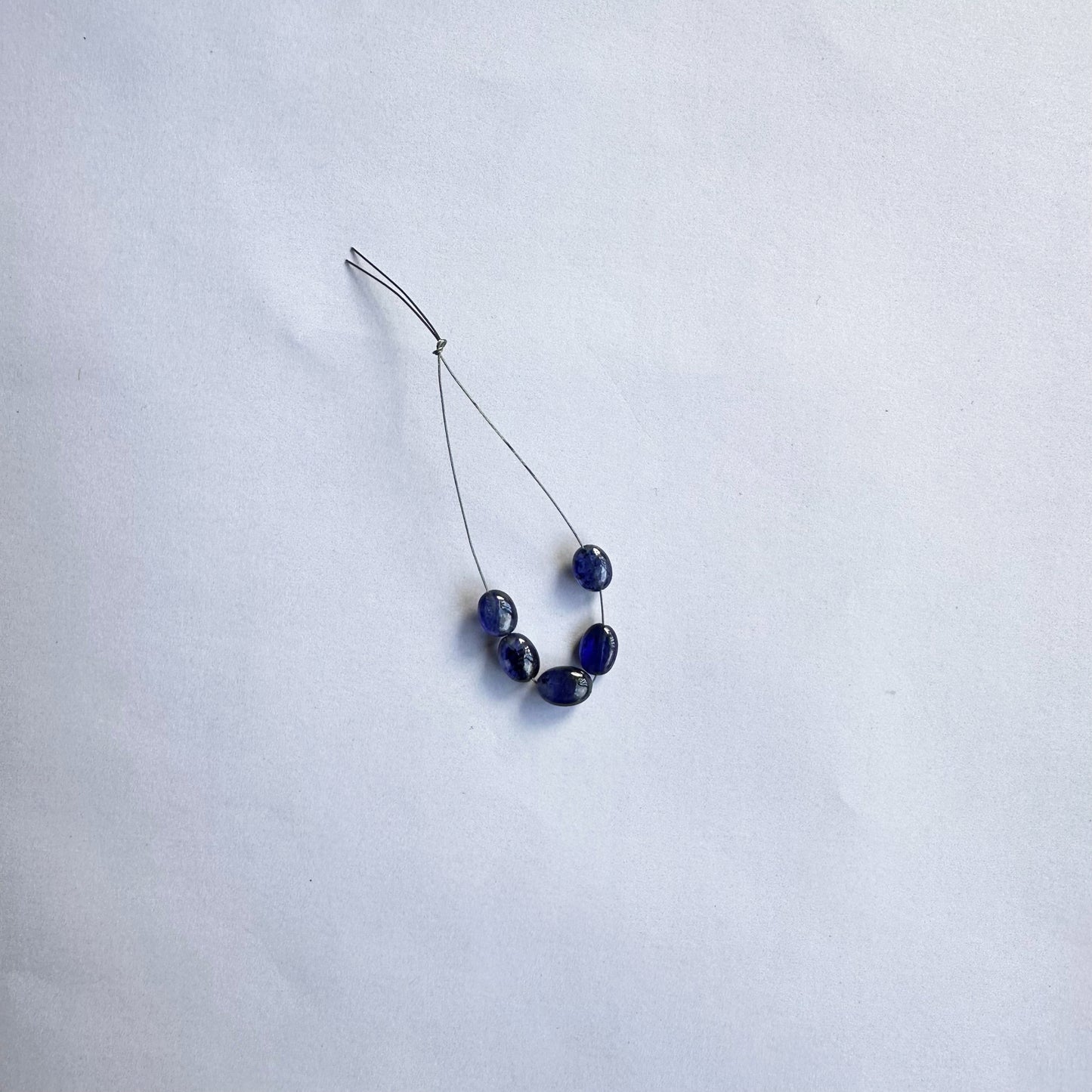 Blue Sapphire smooth oval beads gleam with rich colour and a flawless polish, arranged neatly in a set of five.