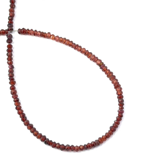 Faceted rondelle Burma Garnet stone beads arranged neatly, highlighting their polished finish and handmade jewellery component quality.