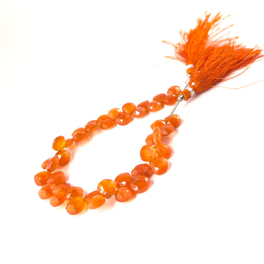 Genuine Carnelian faceted briolette gemstones with fiery colour and polished brilliance across 42 uniformly shaped pieces.