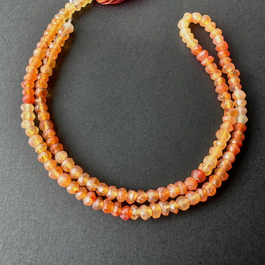 Stone beads with faceted Carnelian arranged neatly, ideal for handmade jewellery components.