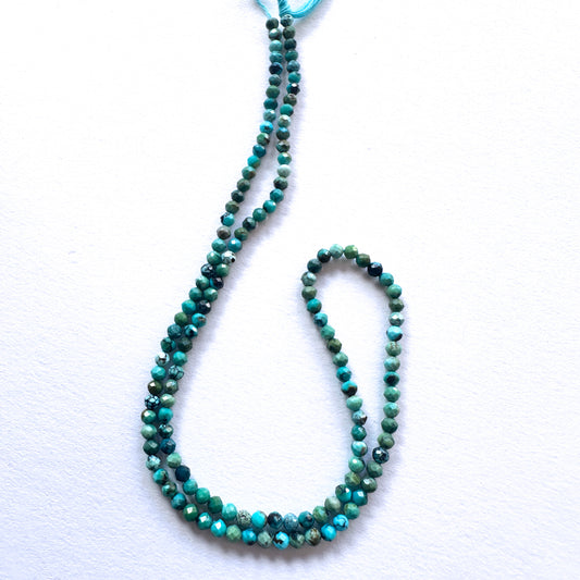 Close-up of Chrysocolla stone beads showing delicate faceting and natural colour variation.