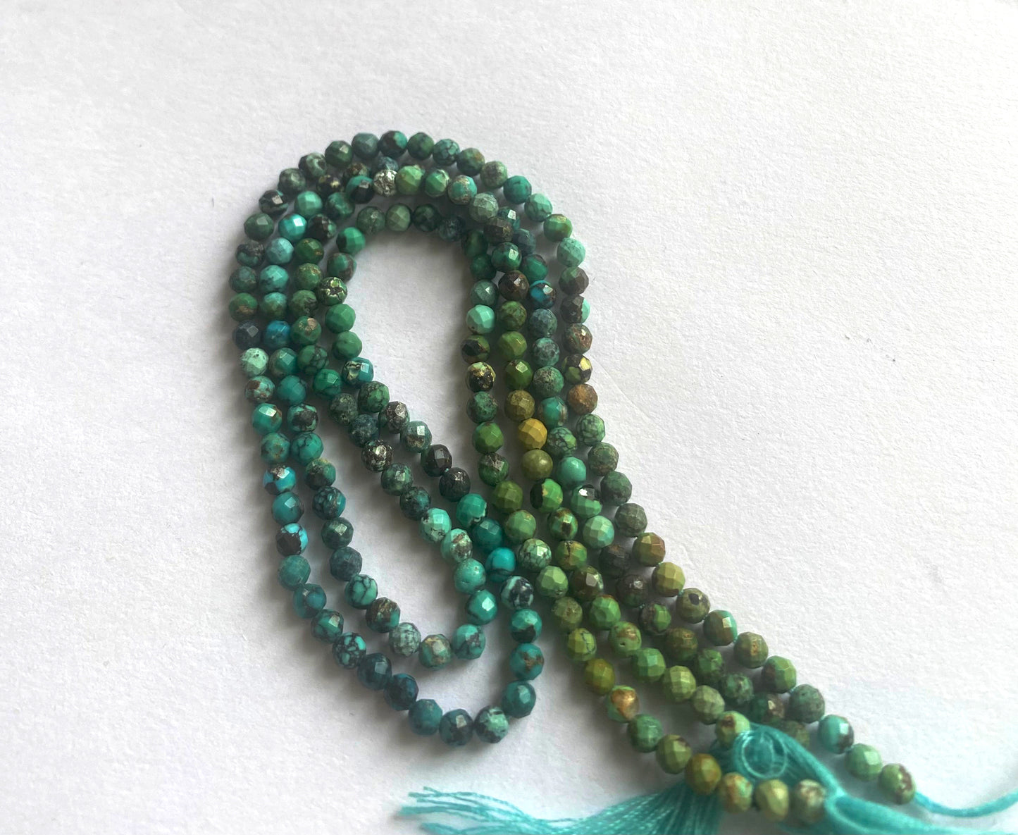 Chrysocolla rondelles arranged on strand with subtle shimmer and rich natural hues.