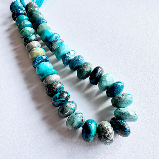 Close-up of 8-9mm Chrysocolla stone beads showing natural colour gradients and smooth surface.