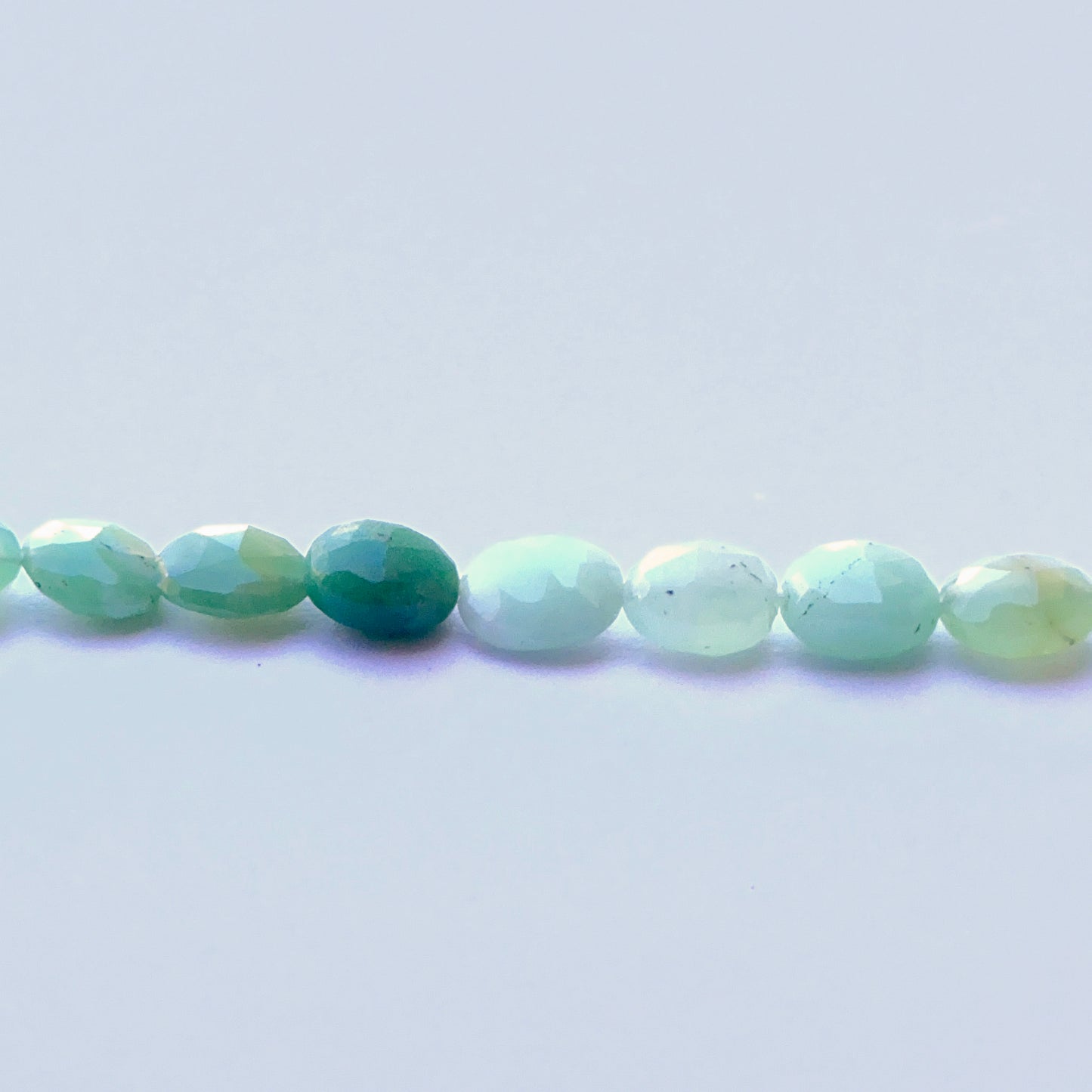 Delicate strands of Chrysoprase beads, showcasing their faceted design.