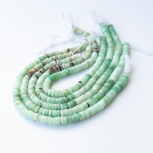 Premium Chrysoprase gemstone beads in smooth wheel cut arranged in strands, highlighting soft green hues for jewellery designers.
